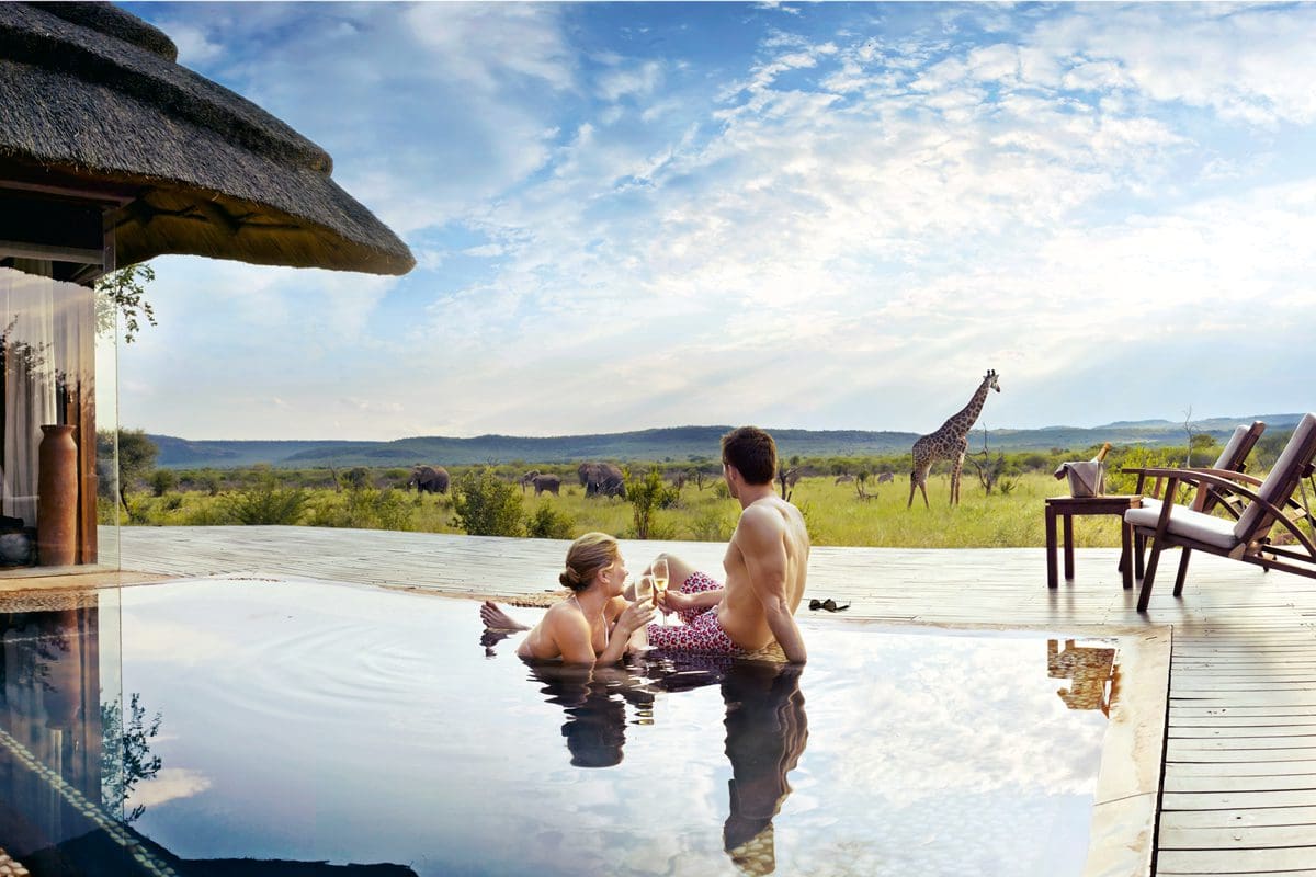 Couple relaxing in a pool at Madikwe Game Reserve Lodge - South African Tourism