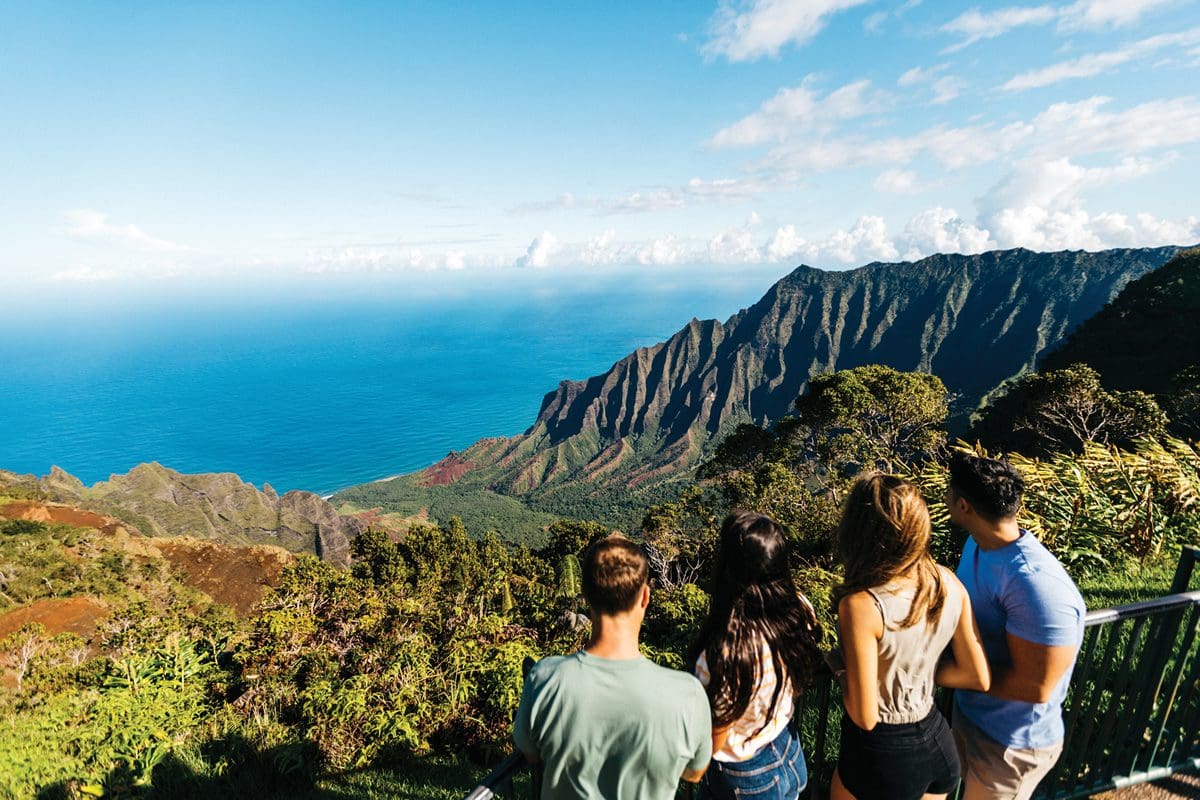 Enjoying the view from Kalalau Lookout in Kauai - Hawaii Tourism Authority