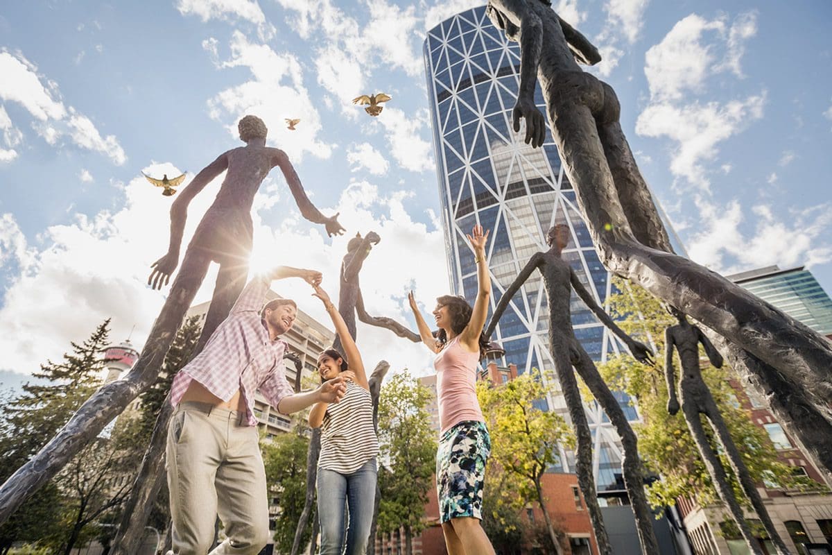 Fun at the Family of Man sculpture in Downtown Calgary - Travel Alberta