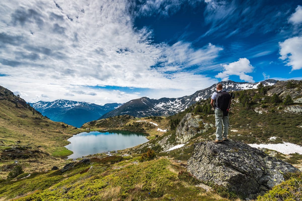 Hiker admiring Lake Tristaina in Andorra