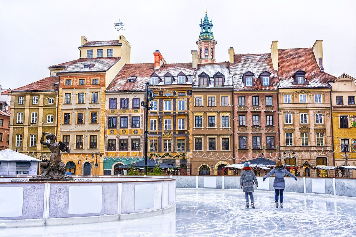Two girls ice skating in the Old Town Square ice rink during Christmas