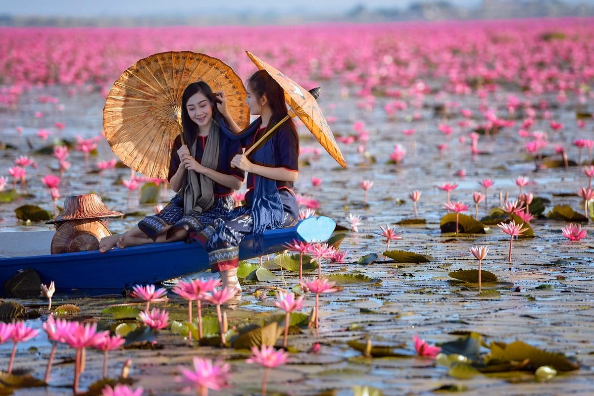 Laos ladies navigating lily pads by boat