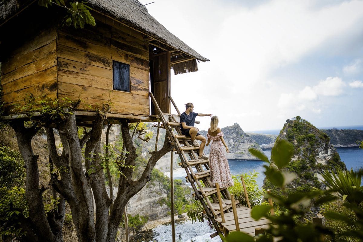 Couple enjoying the views from a tree house in Nusa Penida, Bali - Indonesia Tourism/Fikry Auliya Rahman