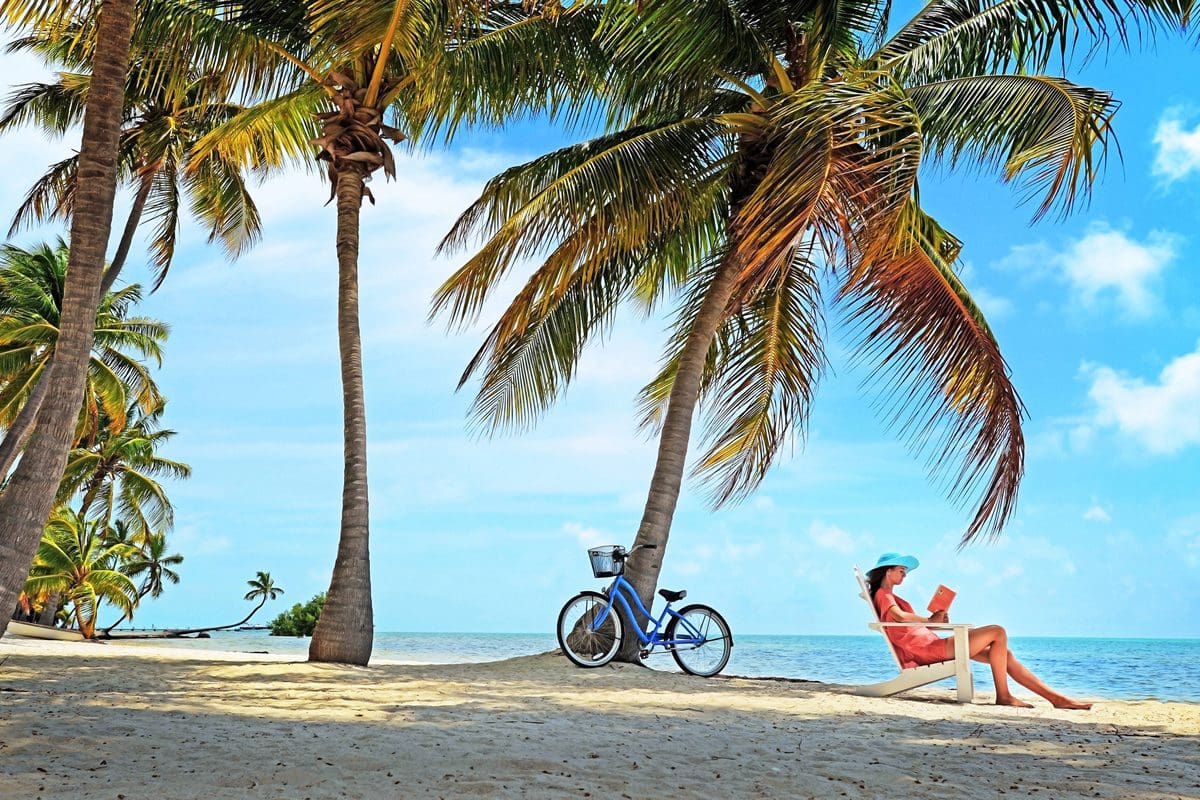 Woman reading a book on the beach at Moorings Village & Spa. Islamorada - Visit Florida/Patrick Farrell/Peter W. Cross