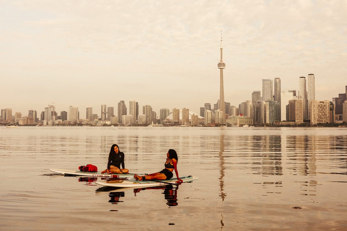 Women on paddleboards with a view of the Toronto Skyline - Destination Ontario