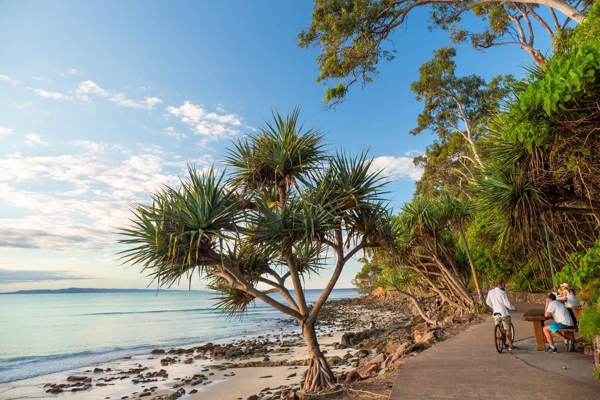 Cycling by the seafront in Noosa - Tourism Australia