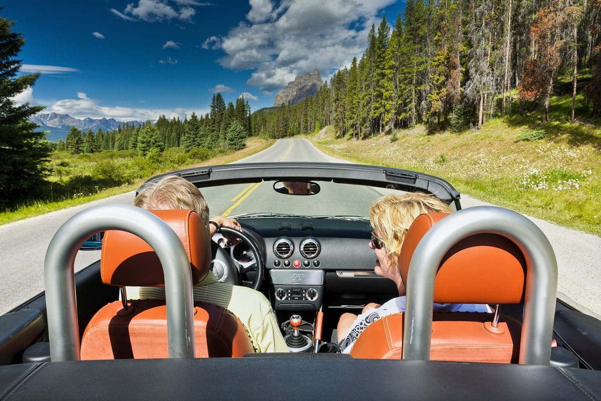 Couple driving through Banff National Park, Alberta - Banff & Lake Louise Tourism