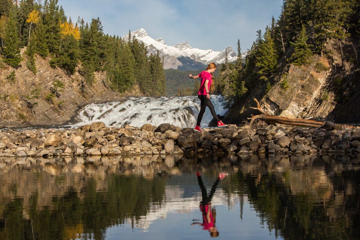 Girl walking by Bow Falls - Banff & Lake Louise Tourism