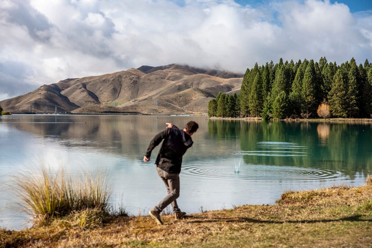 Skimming stones on Lake Ruataniwha, Canterbury - Tourism New Zealand/Miles Holden