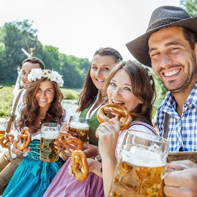 Young group enjoying beer and pretzels during Oktoberfest