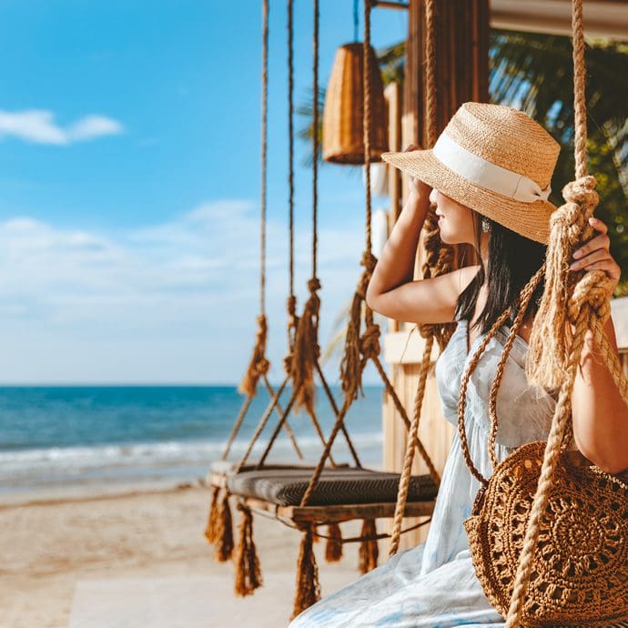 Female solo traveller relaxing by a Thai beach Female solo traveller relaxing by a Thai beach